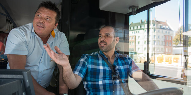 In einem Bus sitzt ein Auszubildender, daneben sein Fahrlehrer In einem Bus sitzt ein Auszubildender, daneben sein Fahrlehrer