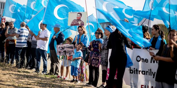 Eine Demonstrantion mit blauen, uigurischen Flaggen Eine Demonstrantion mit blauen, uigurischen Flaggen