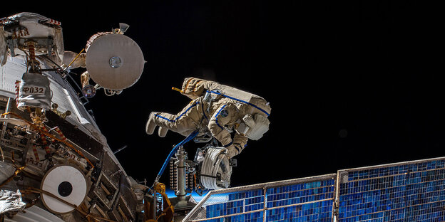 Ein Astronaut befestigt eine Antenne an der Internationalen Raumstation Ein Astronaut befestigt eine Antenne an der Internationalen Raumstation