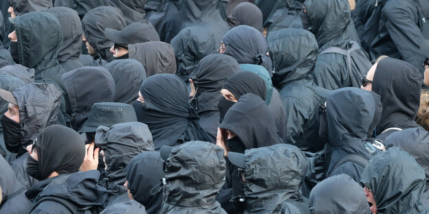 Vermummte Köpfe von Demonstranten Vermummte Köpfe von Demonstranten