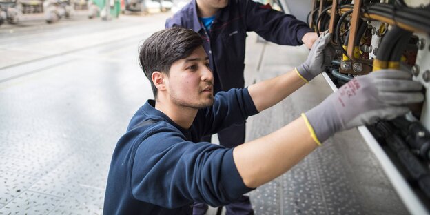 Zwei Männer arbeiten an einer S-Bahn Zwei Männer arbeiten an einer S-Bahn