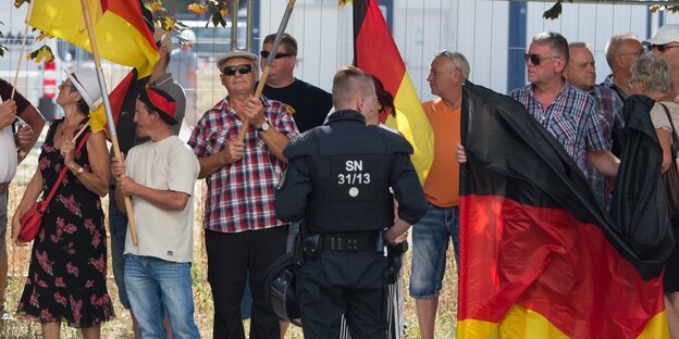Teilnehmer einer Demonstration der islamfeindlichen Pegida-Bewegung stehen anlässlich des bevorstehenden Besuchs von Bundeskanzlerin Merkel (CDU) im Sächsischen Landtag an einer Straßenkreuzung Teilnehmer einer Demonstration der islamfeindlichen Pegida-Bewegung stehen anlässlich des bevorstehenden Besuchs von Bundeskanzlerin Merkel (CDU) im Sächsischen Landtag an einer Straßenkreuzung