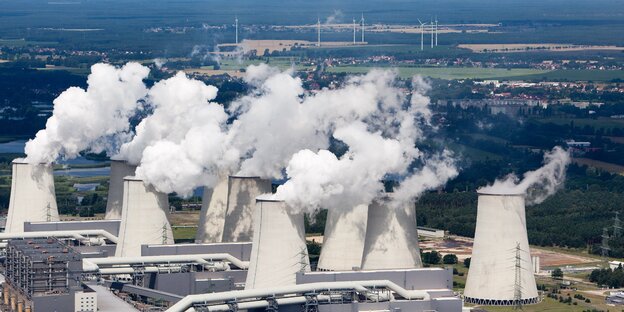 Dampfende Kühltürme, im Hintergrund einige Windkrafträder Dampfende Kühltürme, im Hintergrund einige Windkrafträder
