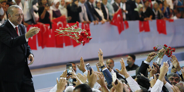 Der türkische Präsident Erdogan wirft einer Menschenmenge Rosen zu Der türkische Präsident Erdogan wirft einer Menschenmenge Rosen zu
