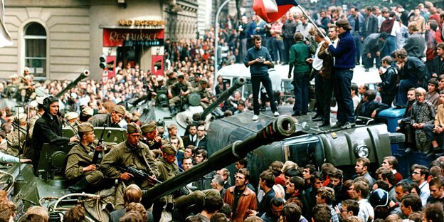 Menschenmenge mit Fahne umringt einen Panzer Menschenmenge mit Fahne umringt einen Panzer