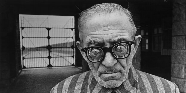 Schwarz-Weiß-Bild eines Mannes mit auffälliger Brille und gestreiftem Sakko Schwarz-Weiß-Bild eines Mannes mit auffälliger Brille und gestreiftem Sakko
