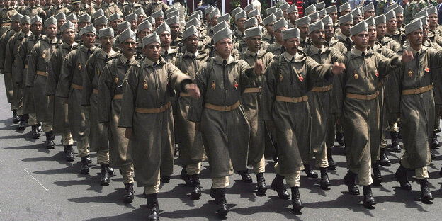 Mehrere Reihen marokkanischer Soldaten, die eine Straße entlangmarschieren Mehrere Reihen marokkanischer Soldaten, die eine Straße entlangmarschieren