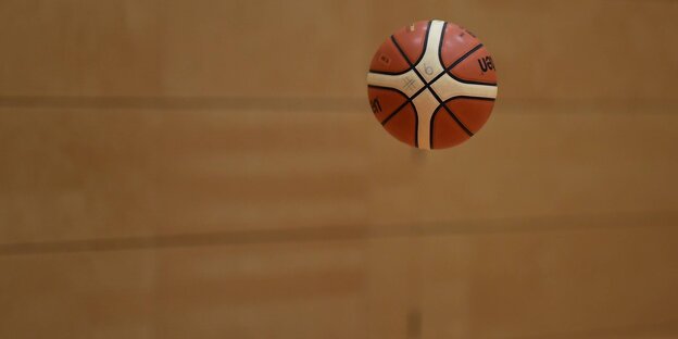 Ein Basketball fligt über dem Hallenboden Ein Basketball fligt über dem Hallenboden