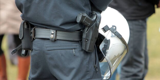 Ein bewaffneter Polizist mit verschränkten Armen Ein bewaffneter Polizist mit verschränkten Armen