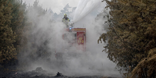 Ein Feuerwehrmann auf einem Einsatzfahrzeug Ein Feuerwehrmann auf einem Einsatzfahrzeug