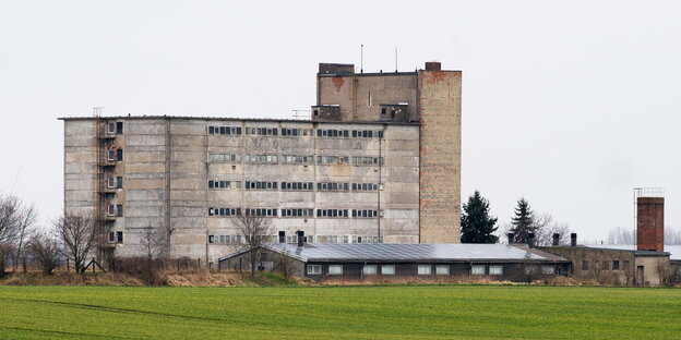 Ein sechsstöckiges Gebäude hinter einem Feld Ein sechsstöckiges Gebäude hinter einem Feld