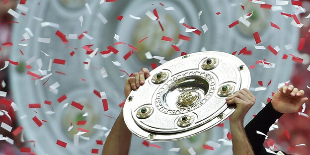 Jemand hält eine Silberschale in den Händen vor dem Bild einer Silberschale Jemand hält eine Silberschale in den Händen vor dem Bild einer Silberschale