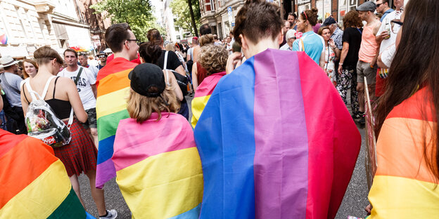 Menschen in Regenbogenflaggen gehüllt Menschen in Regenbogenflaggen gehüllt