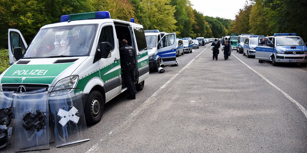 Polizeifahrzeuge parken links und rechts einer Straße