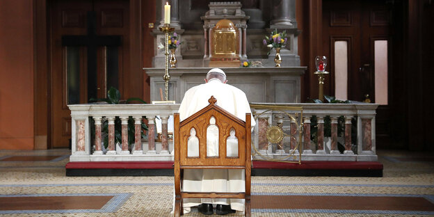 Der Papst von hinten - in einem Stuhl sitzend vor dem Altar in einem Kirchenraum Der Papst von hinten - in einem Stuhl sitzend vor dem Altar in einem Kirchenraum