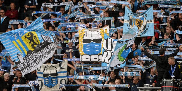 Fans des FC Chemnitz halten Transparente und Schals in die Höhe Fans des FC Chemnitz halten Transparente und Schals in die Höhe