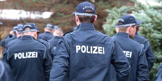 Die Rückenansicht von mehreren Polizisten mit Caps Die Rückenansicht von mehreren Polizisten mit Caps