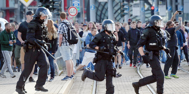 Polizisten rennen über eine Straße Polizisten rennen über eine Straße