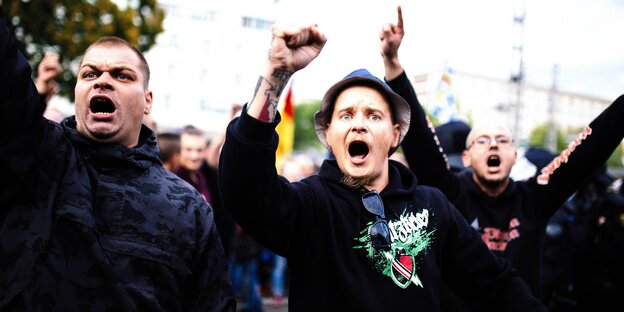 Rechte Demonstranten schreien mit erhobener Faust in Richtung Kamera Rechte Demonstranten schreien mit erhobener Faust in Richtung Kamera