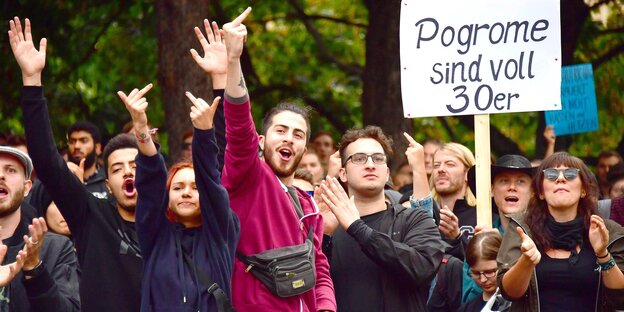 In Chemnitz, mehrere Menschen zeigen den Stinkefinger in Richtung der Kamera, hinter ihnen wird ein Plakat in die Höhe gehalten mit der Aufschrift: Progrome sind voll 30er In Chemnitz, mehrere Menschen zeigen den Stinkefinger in Richtung der Kamera, hinter ihnen wird ein Plakat in die Höhe gehalten mit der Aufschrift: Progrome sind voll 30er