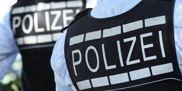 Polizisten von hinten in Warnwesten Polizisten von hinten in Warnwesten