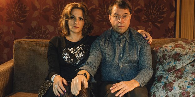 Szene aus Arthurs Gesetz: Martina Gedeck und Jan Josef Liefers sitzen auf einem Sofa, Liefers hat eine Handprothese