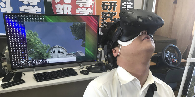 Mann guckt durch eine Virtual-Reality-Brille Mann guckt durch eine Virtual-Reality-Brille
