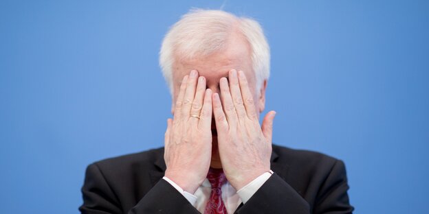 Ein alter weißer Mann hält sich die Hände vors Gesicht Ein alter weißer Mann hält sich die Hände vors Gesicht