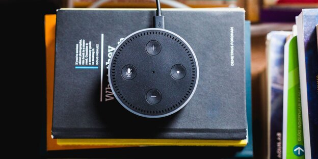 Amazon Echo auf einem schwarzen Buch Amazon Echo auf einem schwarzen Buch