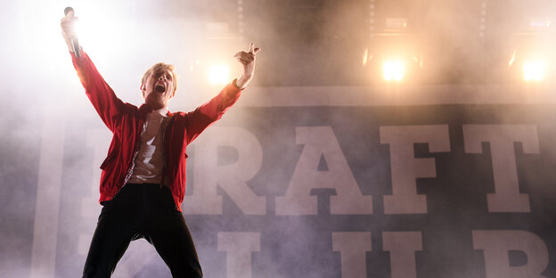 Felix Brummer, der Sänger von Kraftklub, reißt auf der Bühne die Hände in die Luft Felix Brummer, der Sänger von Kraftklub, reißt auf der Bühne die Hände in die Luft