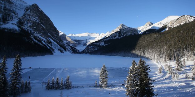 Winterlandschaft mit zugefrorenem See und weißen Berghängen Winterlandschaft mit zugefrorenem See und weißen Berghängen