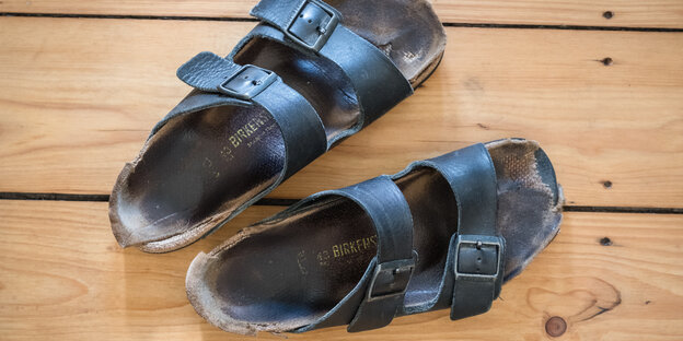 Ein paar blaue, ausgelatschte Gesundheitssandalen, Marke Birkenstock Ein paar blaue, ausgelatschte Gesundheitssandalen, Marke Birkenstock