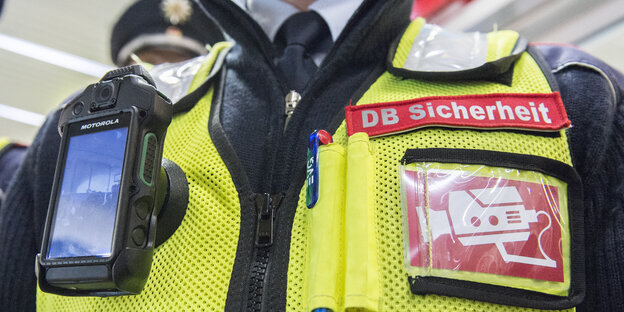 Eine Deutsche Bahn-Uniform mit integrierter Körperkamera. Eine Deutsche Bahn-Uniform mit integrierter Körperkamera.