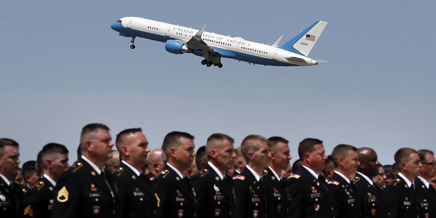 Menschen in Uniform stehen im Vordergrund des Fotos, im Hintergrund ist ein Flugzeug vor blauem Himmel zu sehen. Menschen in Uniform stehen im Vordergrund des Fotos, im Hintergrund ist ein Flugzeug vor blauem Himmel zu sehen.