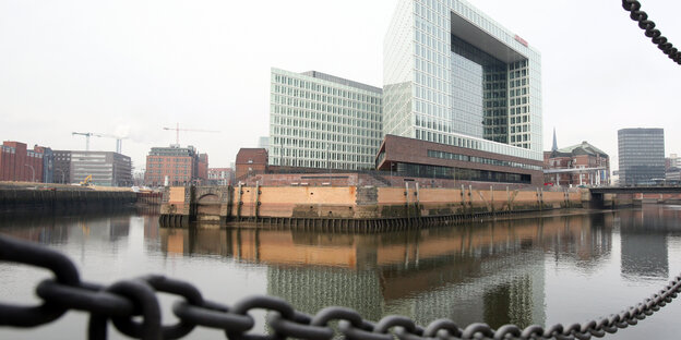 Das Spiegelgebäude am Hafen mit einer Kette davor Das Spiegelgebäude am Hafen mit einer Kette davor