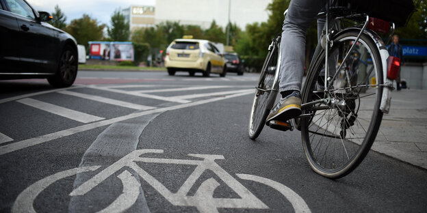 Radfahrer auf Radstreifen, links daneben Autos Radfahrer auf Radstreifen, links daneben Autos