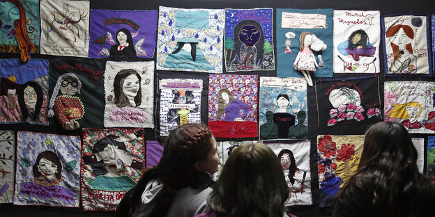 Studentinnen sehen sich ein Kunstwerk mit Gesichtern von ermordeten Frauen an der Technischen Universität von Santiago de Chile an Studentinnen sehen sich ein Kunstwerk mit Gesichtern von ermordeten Frauen an der Technischen Universität von Santiago de Chile an