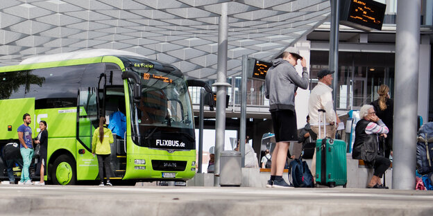 Ein Busbahnhofe mit Reisegästen und einem Flixbus Ein Busbahnhofe mit Reisegästen und einem Flixbus