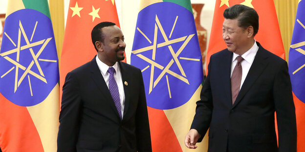 Im Hintergrund bunte Flaggen, im Vordergrund zwei Männer: Abiy Ahmed aus Äthiopien und Xi Jinping aus China. Beide tragen Anzüge und Krawatten Im Hintergrund bunte Flaggen, im Vordergrund zwei Männer: Abiy Ahmed aus Äthiopien und Xi Jinping aus China. Beide tragen Anzüge und Krawatten