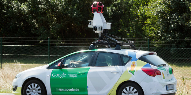 Ein Auto mit einer 360-Grad-Kamera auf dem Dach und Aufschriften von Google Ein Auto mit einer 360-Grad-Kamera auf dem Dach und Aufschriften von Google