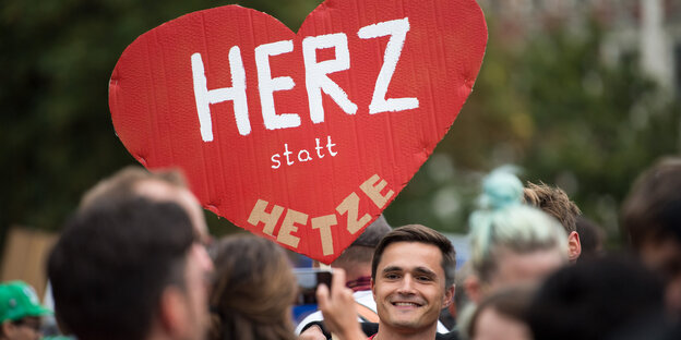 Ein Demonstrant trägt ein Plakat in Herzform in Chemnitz Ein Demonstrant trägt ein Plakat in Herzform in Chemnitz