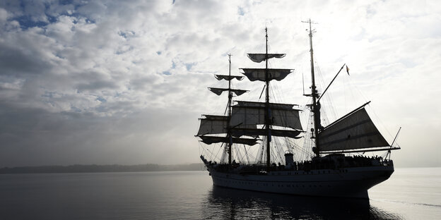 EIn Segelschiff vor bewölktem Himmel bei ruhiger See