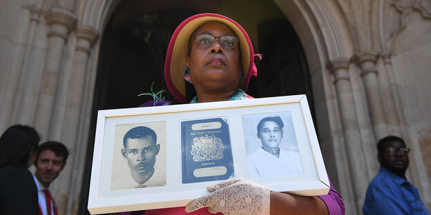 Eine Frau hält ein Bild ihrer Eltern aus der Windrush-Generation in den Händen Eine Frau hält ein Bild ihrer Eltern aus der Windrush-Generation in den Händen