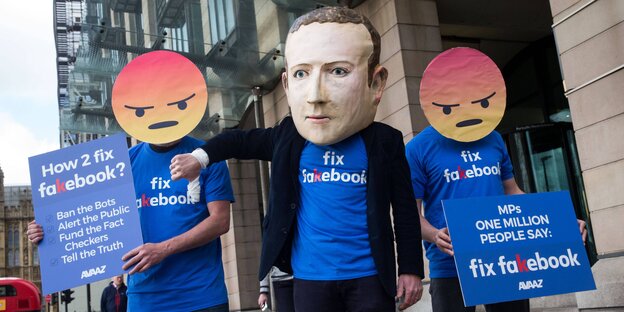 Verkleidete Aktivisten mit Emojis und Zuckerberg-Maske protestieren gegen Fake News auf Facebook Verkleidete Aktivisten mit Emojis und Zuckerberg-Maske protestieren gegen Fake News auf Facebook