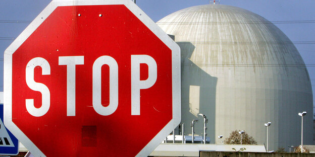 Ein großes Stopp-Schild steht vor der Kuppel eines AKW: Vattenfall klagt auf Entschädigung wegen des Atomausstiegs Ein großes Stopp-Schild steht vor der Kuppel eines AKW: Vattenfall klagt auf Entschädigung wegen des Atomausstiegs