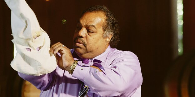 Daryl Davis streift eine KKK-Kapuze über seine Hand Daryl Davis streift eine KKK-Kapuze über seine Hand