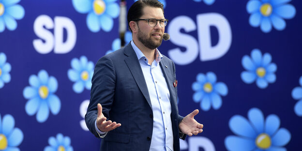 Schwedendemokraten-Chef Jimmie Åkesson spricht vor einer geblümten Werbewand mit Parteilogo Schwedendemokraten-Chef Jimmie Åkesson spricht vor einer geblümten Werbewand mit Parteilogo