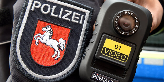 Polizist präsentiert eine Bodycam Polizist präsentiert eine Bodycam