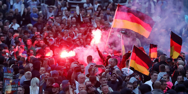 Viele Menschen mit Fahnen und Pyrotechnik