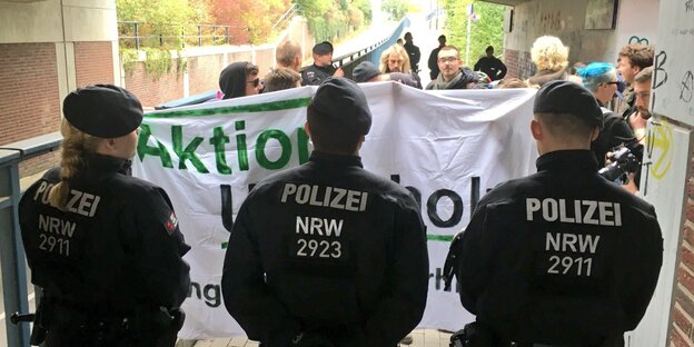 Drei Polizisten stehen vor AktivistInnen der Aktion Unterholz Drei Polizisten stehen vor AktivistInnen der Aktion Unterholz